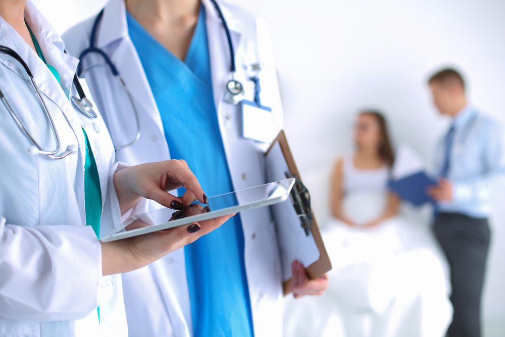 Young,Woman,Doctor,Holding,A,Tablet,Pc Young,Woman,Doctor,Holding,A,Tablet,Pc